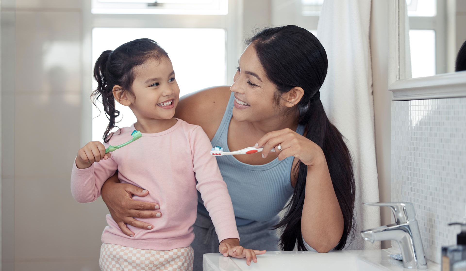 mother and daughter brushing teeth